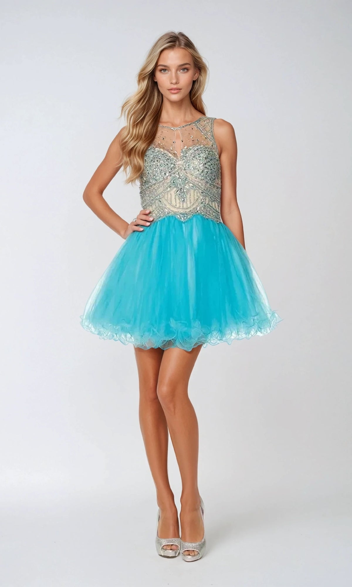 A woman wears the Juliet 761 short party dress—a turquoise mini with a beaded, semi-sheer bodice and an a-line tulle skirt—against a light background, perfect for a chic hoco look.